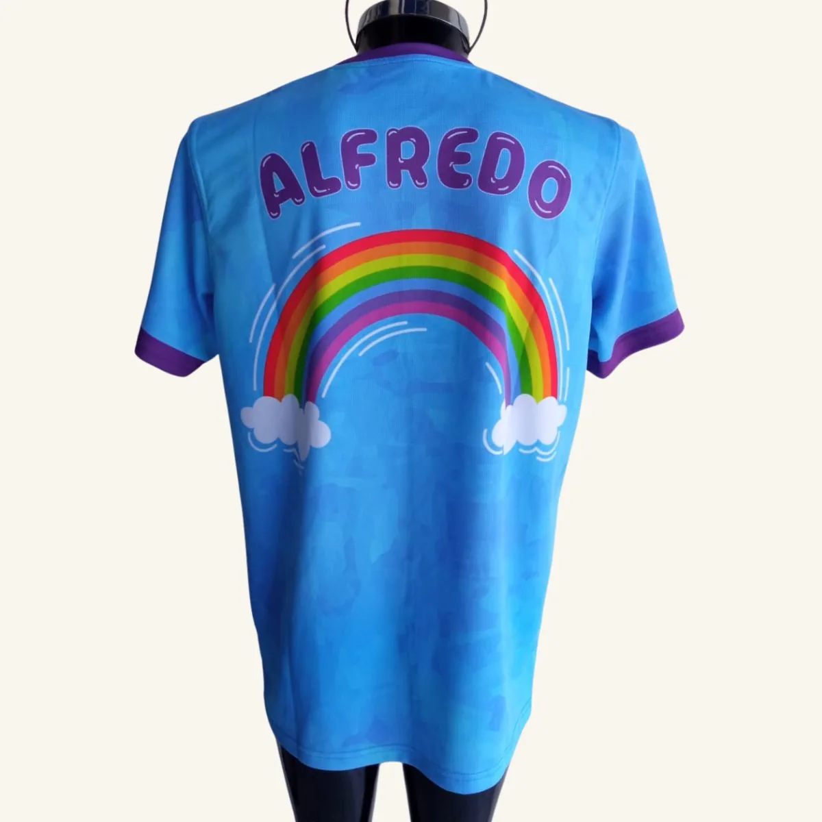 Playera escolar Colegio Ashanao, vista trasera con nombre de alumno y arcoíris