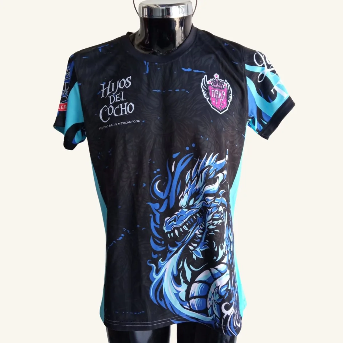 Uniforme de fútbol personalizado para el equipo Hijos del Cocho con escudo y dragón azul